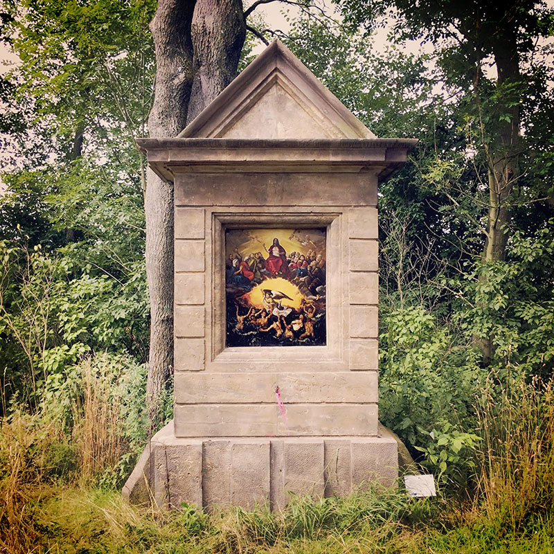 Man merkt, dass wir in einer katholischen Gegend wandern. Immer wieder begegnen uns Kreuze am Wegesrand. Mal so opulent wie dieses, mal heruntergekommen. Aber immer beachtet und wahrgenommen.