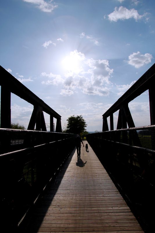 Über die Brücke der bereits tief stehenden Sonne entgegen starten meine Freunde und ich unsere Wanderung entlang der Unstrut in Artern.